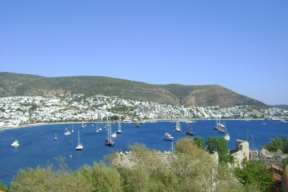 Bodrum körfezinin geniş açılı görünümü, demirli tekneler ve arkada tepeler
