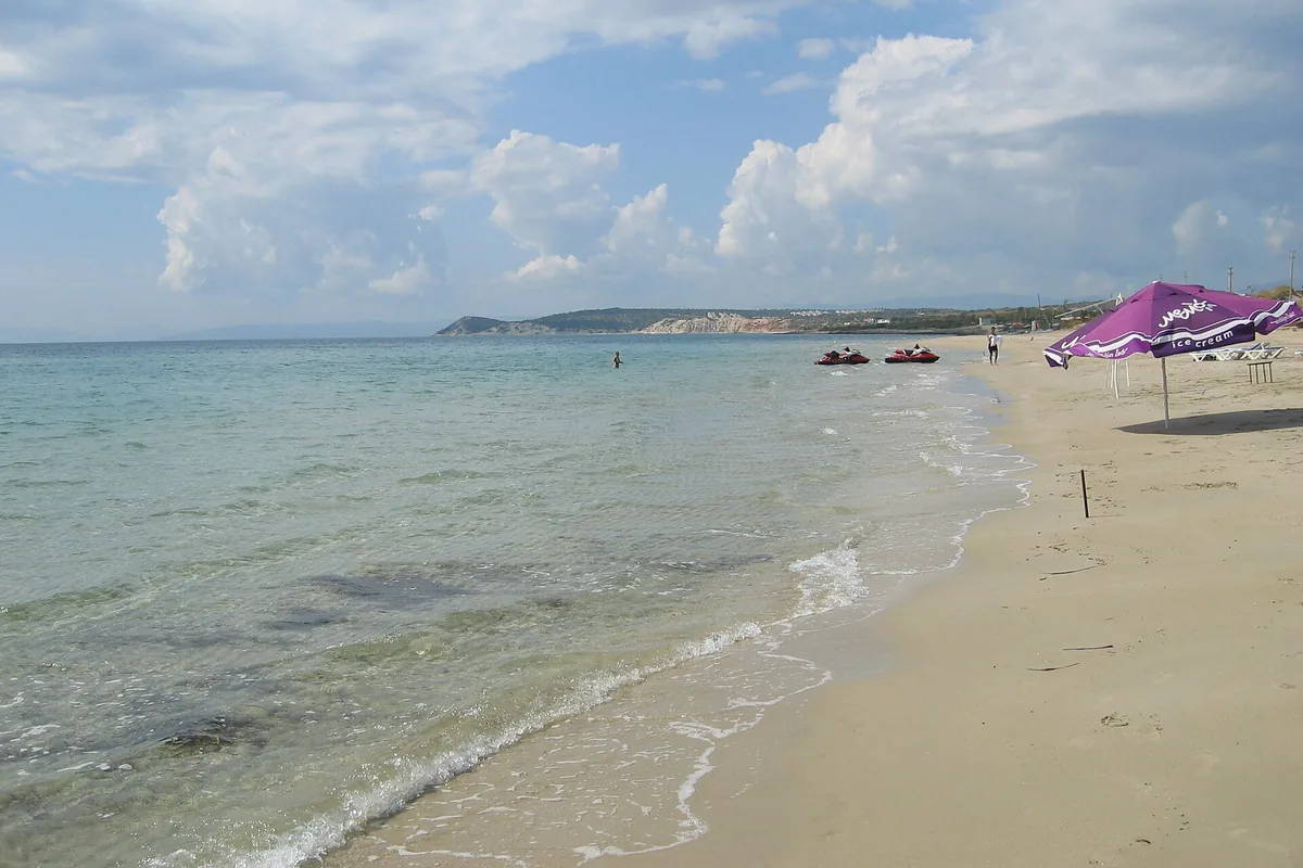 Çeşme Altınkum'da ince kumsal, sığ ve turkuaz su, kıyıda yürüyen ziyaretçiler