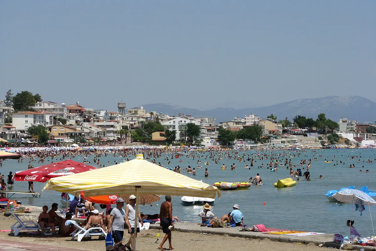 Altınkum Plajı sezon ortasında, şemsiyeler ve gerideki yerleşim