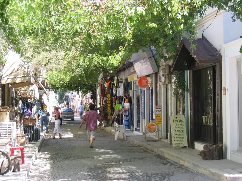 Foça çarşısında ağaç gölgesindeki dükkan sokağı