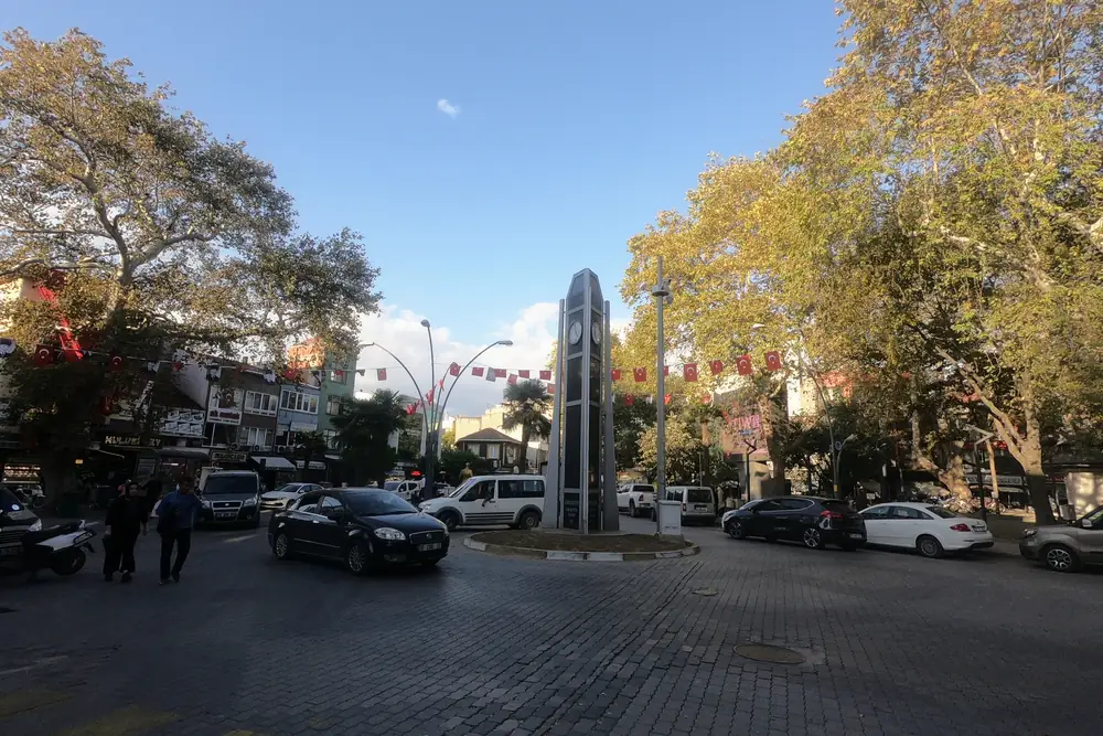 Gönen'in merkezindeki Ömer Seyfettin Meydanı'nda anıt, Türk bayrakları ve çevresindeki çarşı