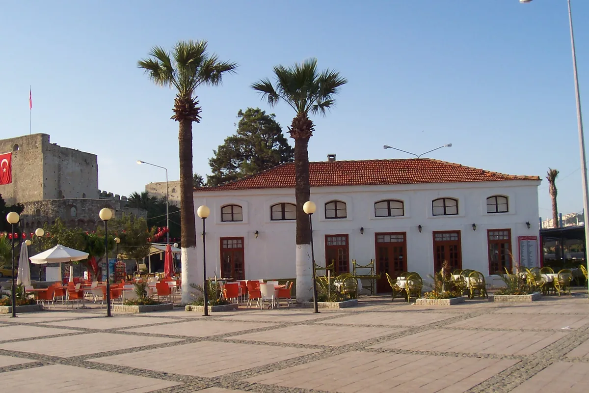 Çeşme merkezde kale yanındaki meydan, palmiyeler ve tarihi bina