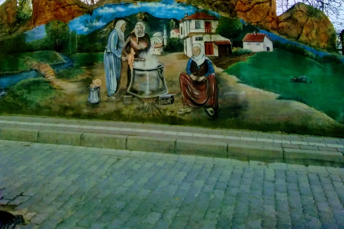 Manyas çarşısında geleneksel peynir kaynatma sahnesini gösteren bir duvar resmi (mural)