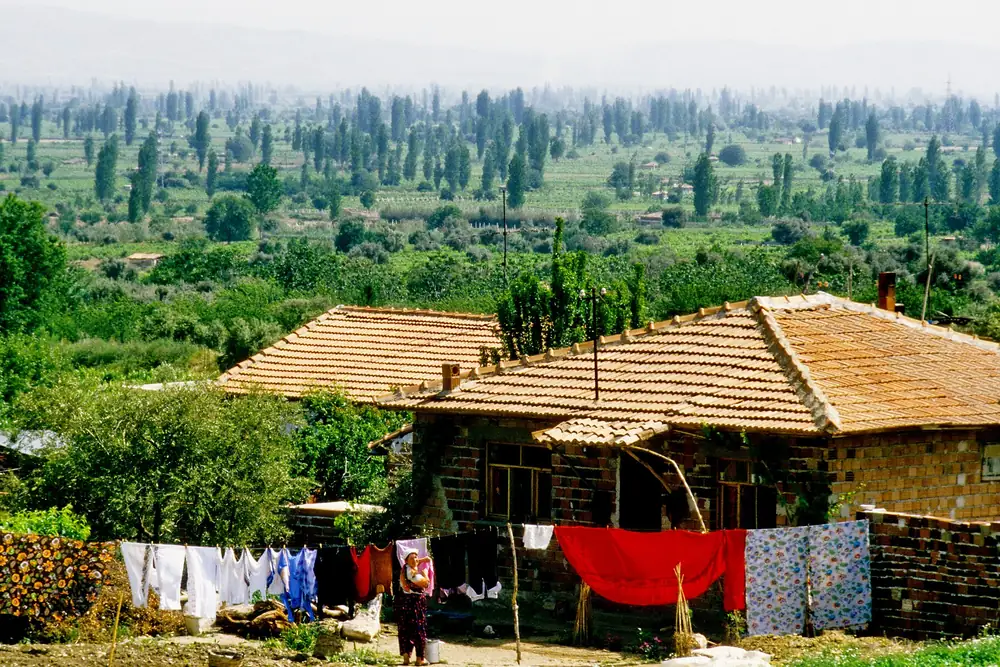 Derbent Mahallesi'nde geleneksel bir köy evi ve bahçesinde asılı çamaşırlar, 1988 tarihli fotoğraf