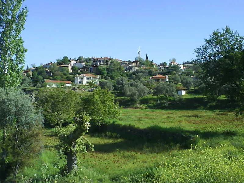 Yatağan kırsalında bahar mevsiminde tepede köy ve minare